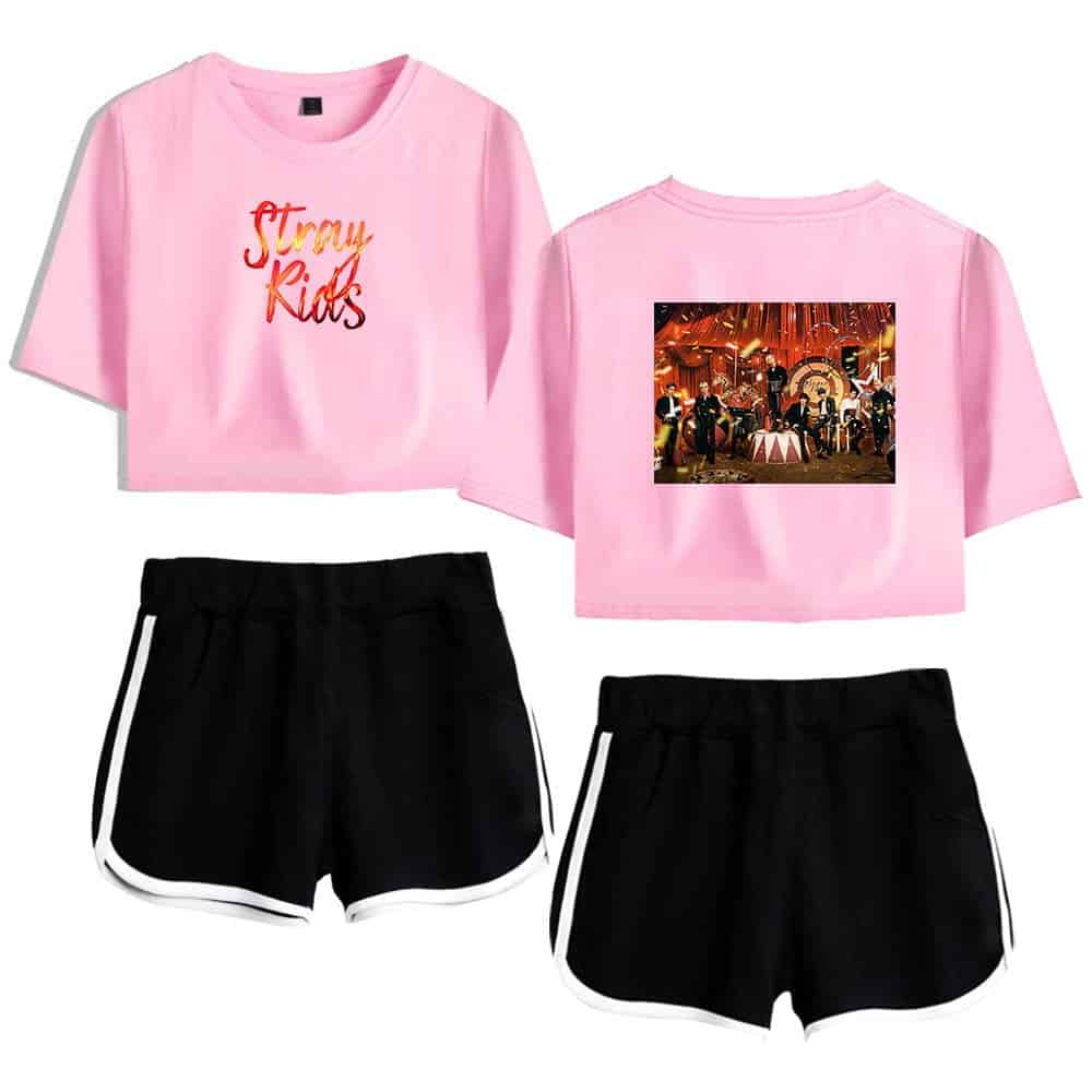 Pink cropped t-shirt with "Stray Kids" logo and concert image on back, black athletic shorts with white trim, Justin Bieber swag merchandise, trendy casual clothing, popular singer-inspired streetwear.