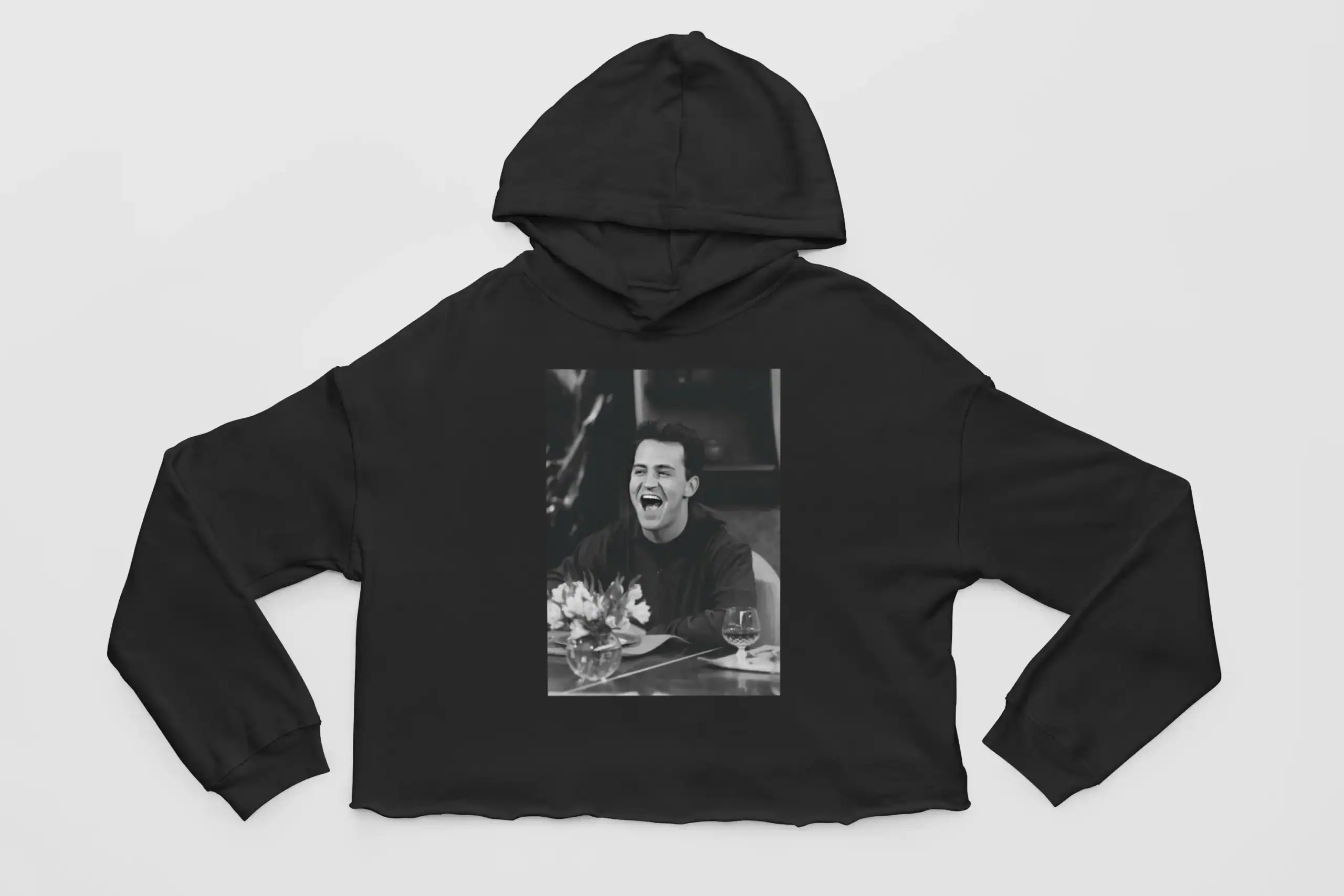 Justin Bieber swag merch hoodie with a black and white printed photo of him laughing at a dinner table. The hoodie features a relaxed fit and casual style, perfect for fans of Justin Bieber’s fashion and music.