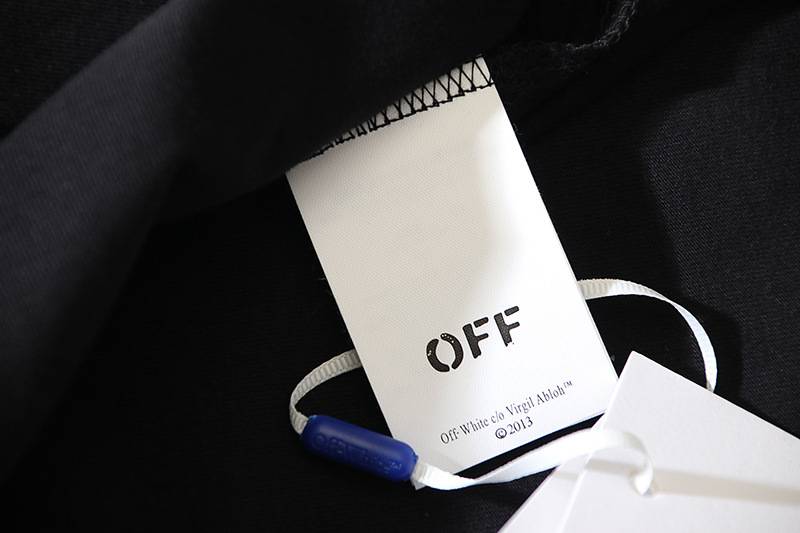 Black OFF-brand clothing tag on a dark fabric, part of Justin Bieber swag merch collection.