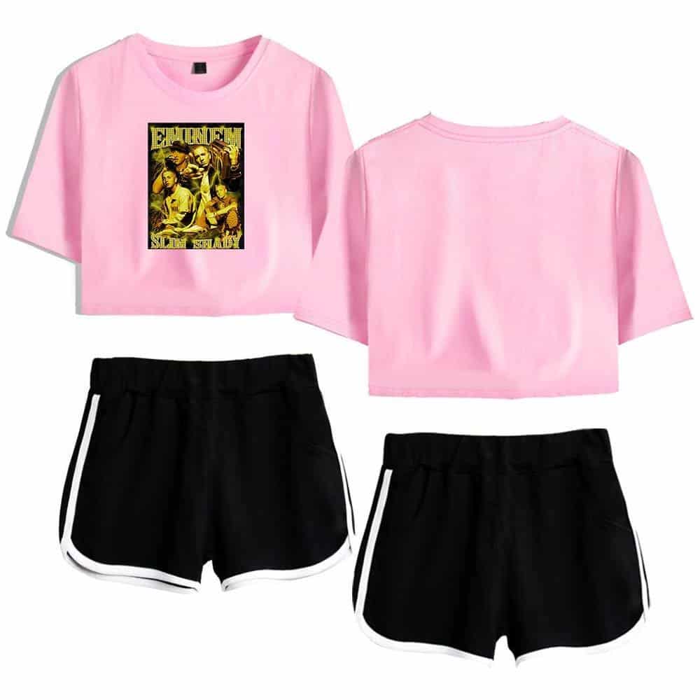 Pink crop top with black and yellow graphic print, black athletic shorts with white trim for women.