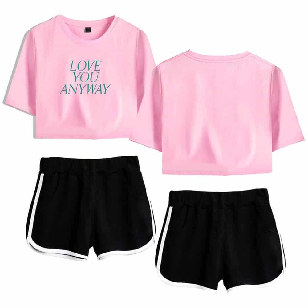 Pink graphic t-shirt with "Love You Anyway" text, black athletic shorts with white trim, casual trendy Justin Bieber swag merch, modern streetwear style, vibrant and youthful.